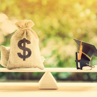photo of scale with bag of money balanced with graduation cap and diploma